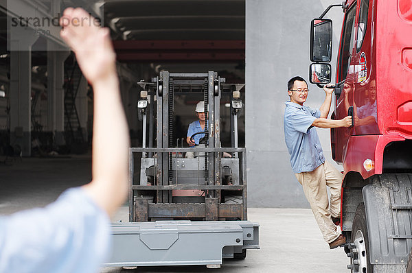 Männlicher Fabrikarbeiter führt Gabelstapler in Kranfabrik  China