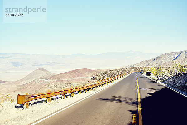 Blick auf eine gerade Wüstenstraße durch die Mesquite Dunes  Death Valley  Kalifornien  USA