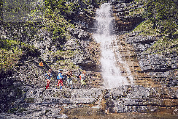 Gruppe von Kindern erkundet den Wasserfall