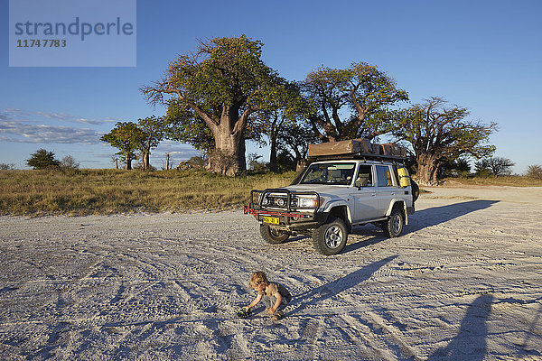 Junge spielt mit Fahrzeug  Nxai-Pan-Nationalpark  Kalahari-Wüste  Afrika