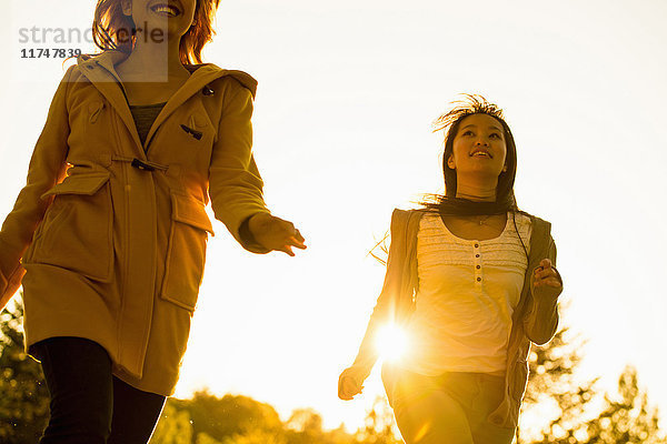 Zwei junge Frauen laufen im Park