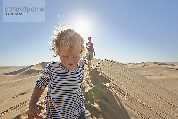 Mutter und Söhne wandern auf einer Sanddüne  Düne 7  Namib-Naukluft-Nationalpark  Afrika