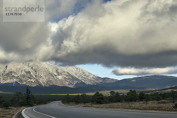 Abnehmende Perspektive der leeren Straße zum Schneeberg des Jadedrachens  Lijiang  Yunnan  China