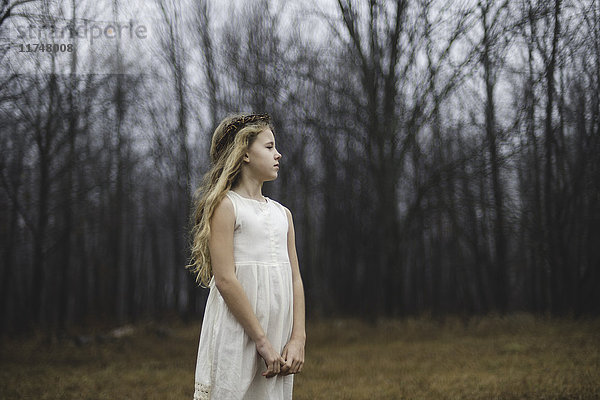 Porträt eines langhaarigen blonden Mädchens  das im Waldfeld wegschaut