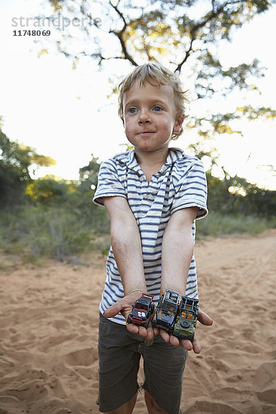 Porträt eines Jungen  der Spielzeugautos hält  Grootfontein  Kavango  Namibia
