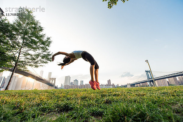 Junge Frau macht Backflips im Park  New York  USA
