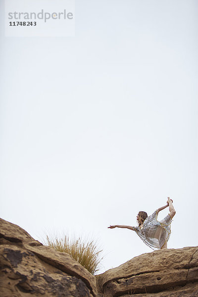 Frau praktiziert Yoga auf einer Felsformation  Stoney Point  Topanga Canyon  Chatsworth  Los Angeles  Kalifornien  USA
