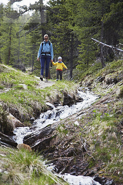 Mutter und Sohn  Händchen haltend  Wald erkunden