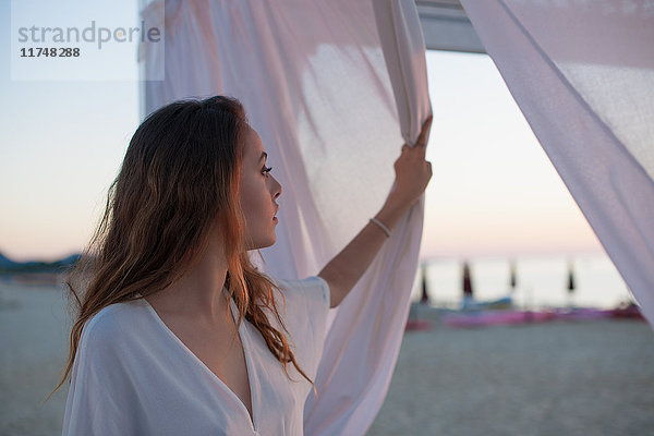 Junge Frau beim Blick vom Strandpavillon  Castiadas  Sardinien  Italien