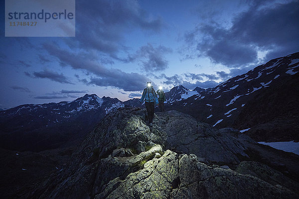 Junges Paar wandert nachts mit Stirnlampen  Schnalstaler Gletscher  Schnalstal  Südtirol  Italien