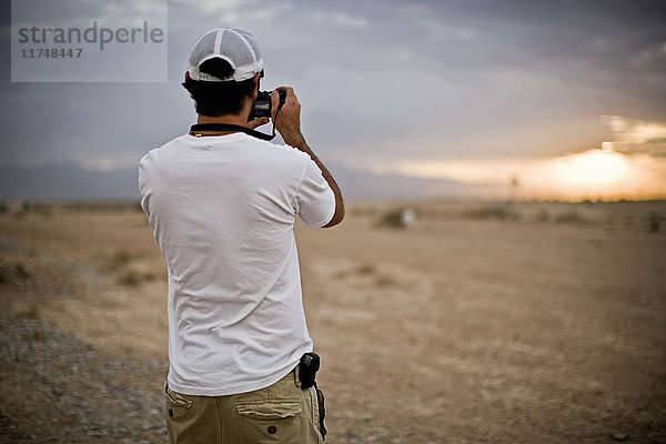 Rückansicht eines Mannes  der Sturmwolken in der Wüste fotografiert  Las Vegas  Nevada  USA