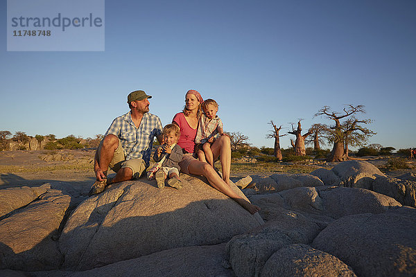 Familie sitzt auf einem Felsen und schaut auf die Aussicht  Gweta  makgadikgadi  Botswana