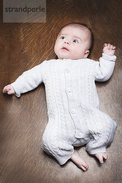 1 - 2 Monate altes Baby Junge auf Holzboden liegend