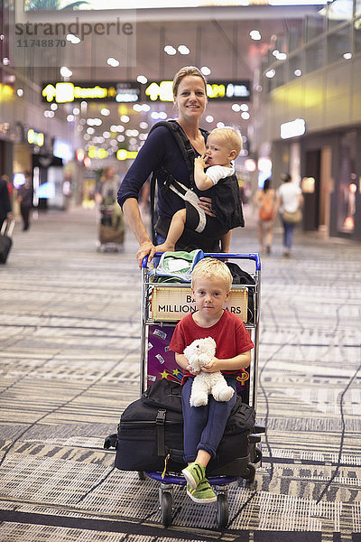 Porträt einer mittleren erwachsenen Frau und zweier Kinder am Flughafen Singapur
