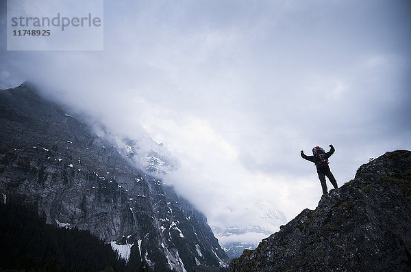 Auf Felsen stehender Mann mit dem Eiger im Hintergrund  Berner Oberland  Schweiz