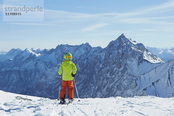 Junge am Bergrand  bereit zum Skifahren  Rückansicht