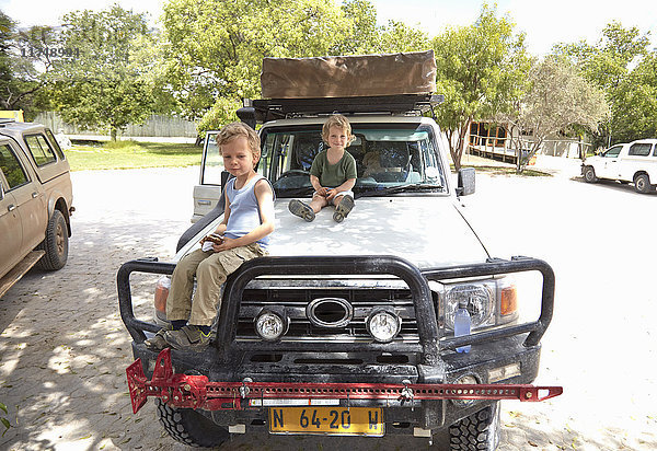 Porträt von zwei Jungen  die auf einem Geländewagen sitzen  Otavi  Etosha  Namibia