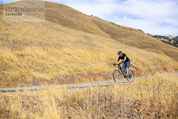 Junger männlicher Mountainbiker auf ländlicher Straße  Mount Diablo  Bay Area  Kalifornien  USA