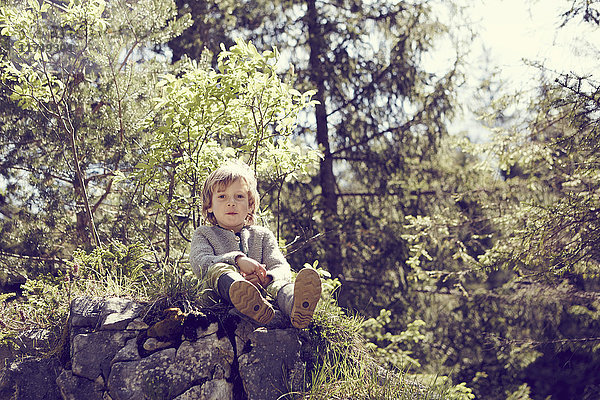 Junge entspannt sich auf Felsen im Wald