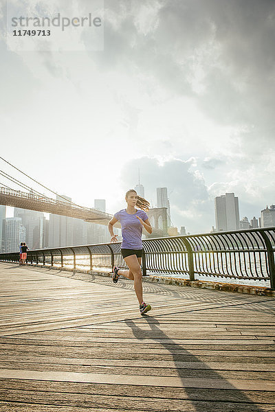 Junge Läuferin läuft am Flussufer  Brooklyn  New York  USA