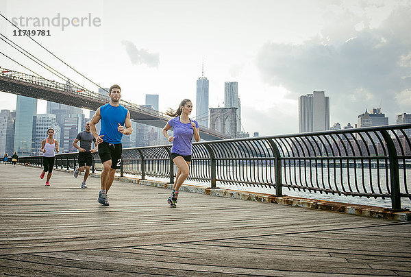 Gruppe von Menschen rennt vor der Brooklyn-Brücke  New York  USA