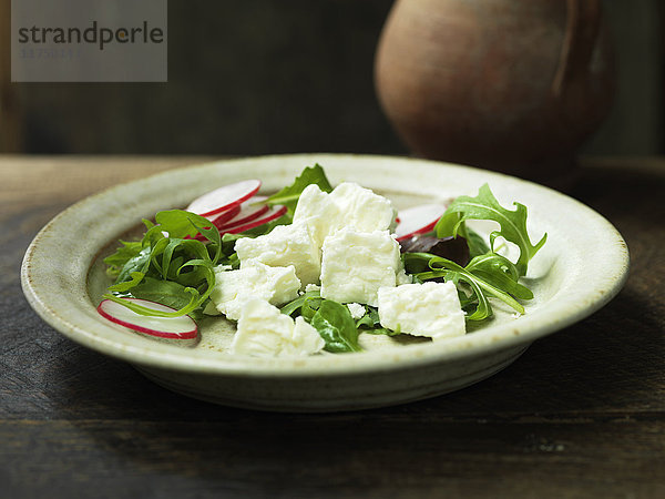 Griechischer Feta-Käse im Salat mit geschnittenen Radieschen und Rucola
