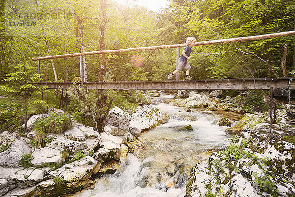 Junge läuft auf Holzsteg  Bovec  Soca  Slowenien