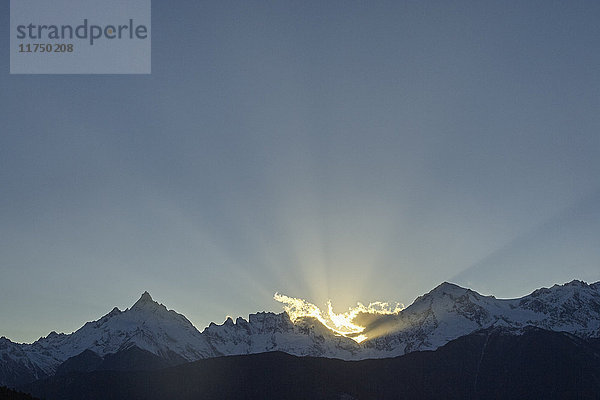 Sonnenstrahlen hinter schneebedeckten Bergen  Bezirk Shangri-la  Yunnan  China