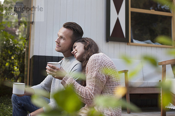 Kaffeetrinkende Paare auf der Veranda des Chalets