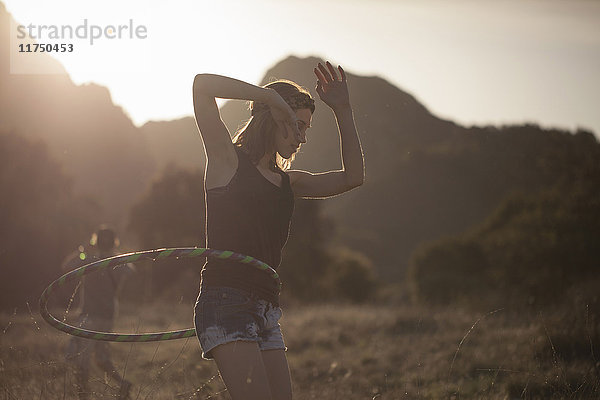 Junge Frau tritt mit einem Hoola-Hoop-Reifen auf  Malibu Creek State Park  Kalifornien  USA