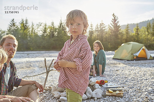 Porträt eines Jungen mit Eltern auf Campingreise  der in die Kamera schaut