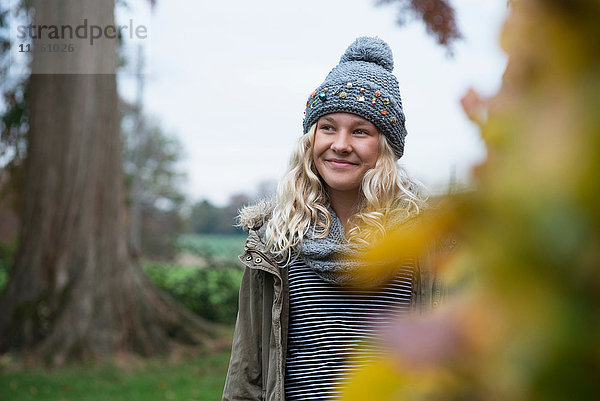 Mädchen mit Strickmütze beim Spaziergang in ländlicher Landschaft