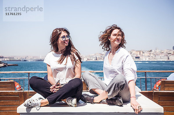Zwei junge Touristinnen auf dem Passagier-Fährdeck im Schneidersitz  Beyazit  Türkei