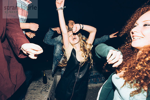 Gruppe von Freunden tanzt  genießt Dachparty bei Nacht