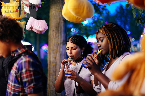 Freunde auf Kirmes  Mädchen trinken Eisgetränke