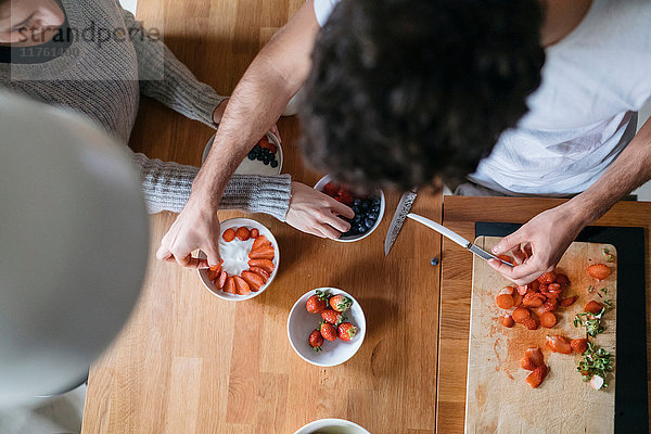 Draufsicht auf ein junges Paar  das an der Küchentheke das Frühstück vorbereitet