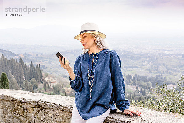 Stilvolle  reife Frau schaut auf Smartphone  Fiesole  Toskana  Italien