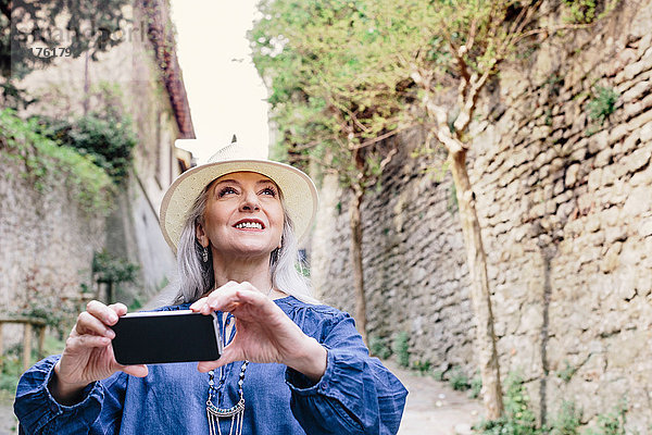 Stilvolle  reife Frau fotografiert von einer gepflasterten Straße aus  Fiesole  Toskana  Italien