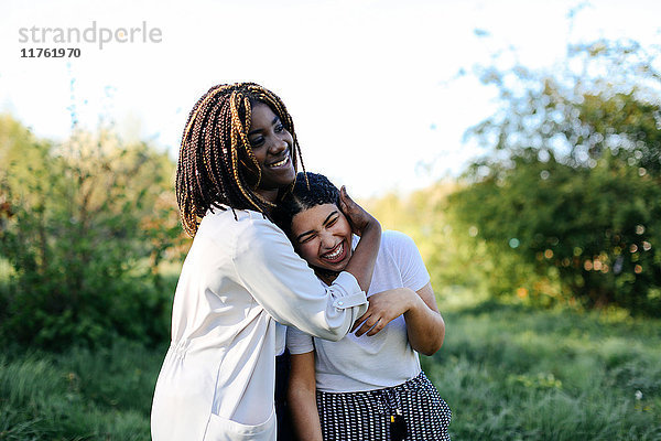 Zwei Mädchen im Teenageralter  die herumalbern  sich umarmen und lachen