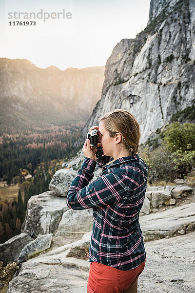 Frau fotografiert Landschaft von einer Felsformation aus  Yosemite National Park  Kalifornien  USA
