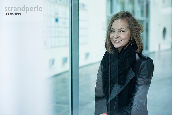 Bürofenster-Porträt einer glücklichen jungen Frau