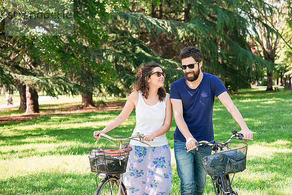 Paar beim Spaziergang mit Fahrrädern im Park  Arezzo  Toskana  Italien