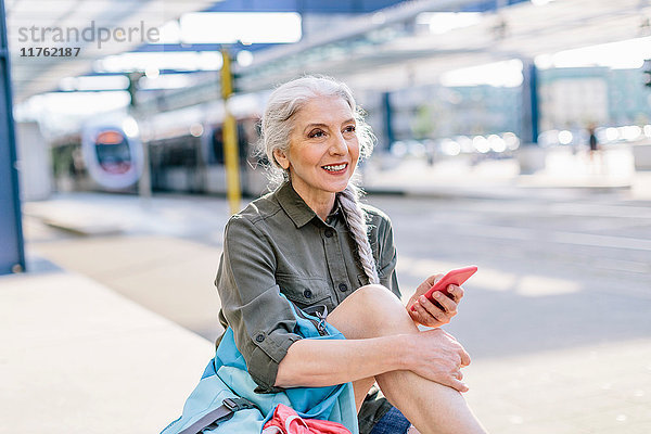 Reife Rucksacktouristin mit Smartphone am Busbahnhof  Scandicci  Toskana  Italien