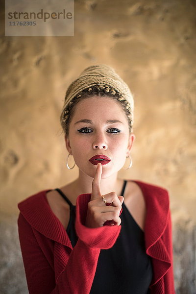 Bildnis einer jungen Frau mit Dreadlocks  Finger an Mund