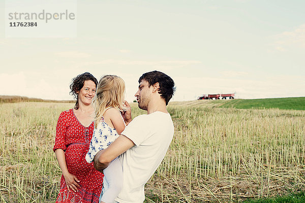 Schwangeres Paar im Weizenfeld mit Kleinkind-Tochter
