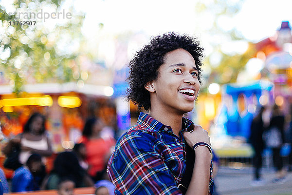 Porträt eines lächelnden Teenagers auf einem Jahrmarkt