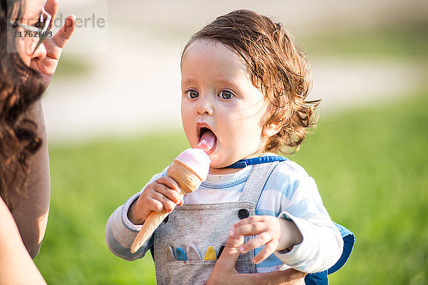 Frau mit Kleinkind-Sohn isst Eistüten im Park