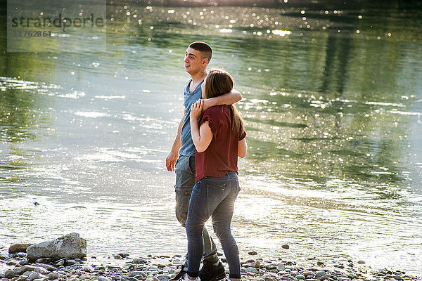 Romantisches Paar beim Spaziergang auf Felsen am Fluss