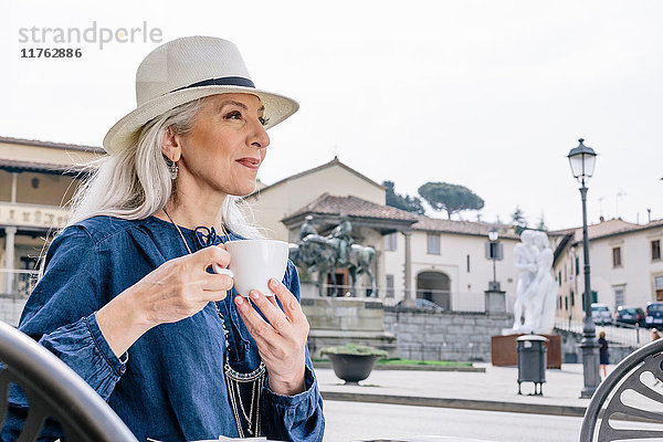 Reife Frau trinkt Kaffee im Strassencafé  Fiesole  Toskana  Italien