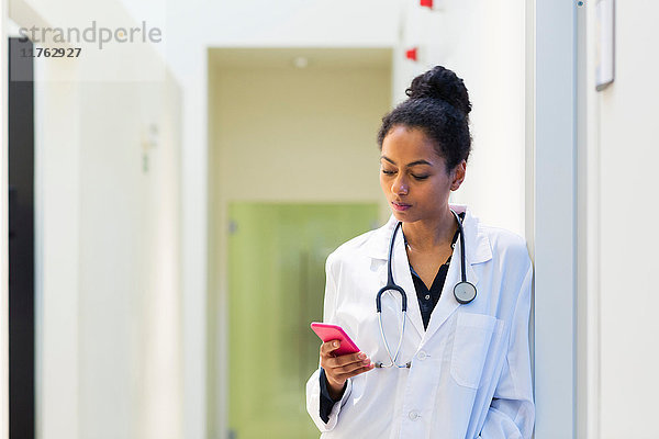 Arzt im Krankenhaus schaut auf Handy